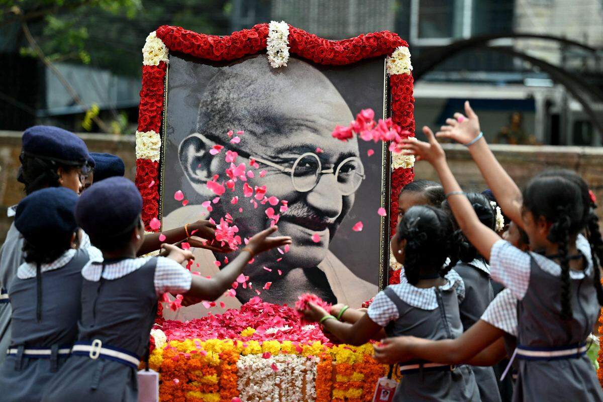 30. Jänner. Indische Schülerinnen und Schüler werfen am 76. Todestag Mahatma Gandhis Rosen auf ein Porträt des Freiheitskämpfers.