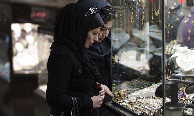 Women look at jewellery at a shop window in a bazaar in northern Tehran