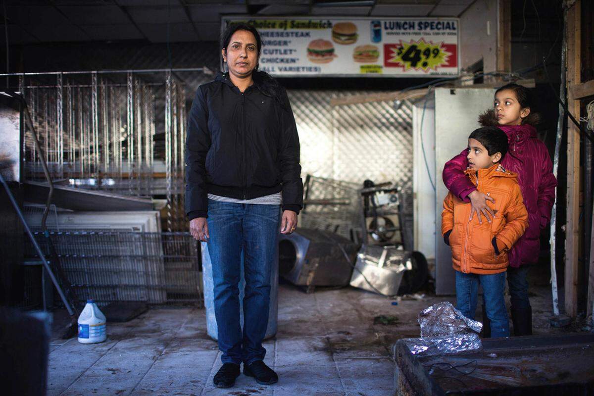 Jaswinder Kaur steht mit ihren Kindern Taranjot und Harshjot in den Ruinen ihres Geschäfts in New Dorp Beach. Die alleinerziehende Mutter blickt einer ungewissen Zukunft entgegen. Das von ihr gemietete Gebäude muss vielleicht abgerissen werden.