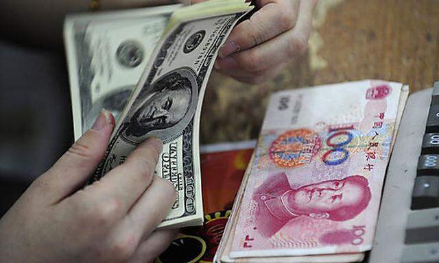A Chinese clerk counts U.S. dollars in exchange for the Chinese renminbi at a bank in Hefei in centra