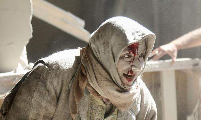An injured woman reacts at a site hit by airstrikes in the rebel held area of Old Aleppo