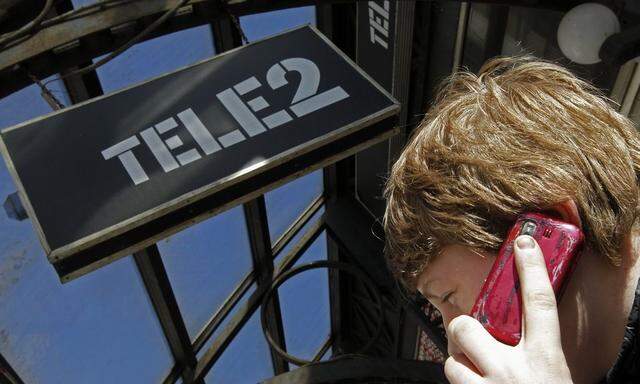 A man talks on a telephone outside a branch of Nordic telecoms group Tele2 in St. Petersburg