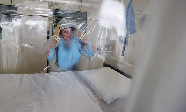 Senior Matron Breda Athan demonstrates putting on the protective suit which would be used if it becomes necessary to treat patients suffering from Ebola, at The Royal Free Hospital in London