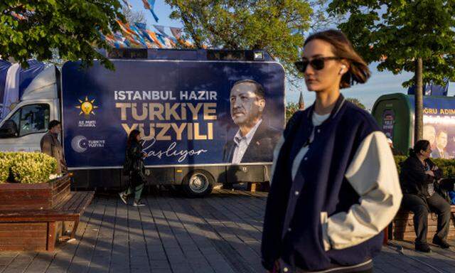 Leute passieren einen LKW mit Wahlwerbung für Recep Tayyip Erdoğan in Istanbul.