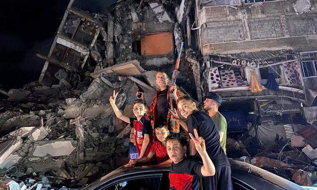 ictory-Zeichen vor den Ruinen in Gaza Stadt. Die Hamas feierte den Beginn der Waffenruhe mit Israel noch in der Nacht auf Freitag als „Sieg“. Viele strömten erstmals seit Ende des Ramadan spätnachts wieder auf die Straßen. 