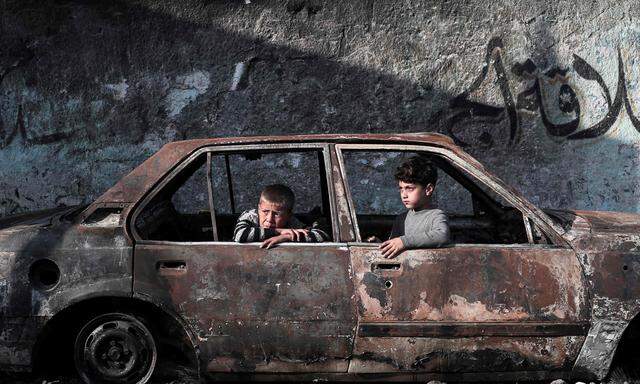 Kinder in einem zerstörten Auto in Rafah.