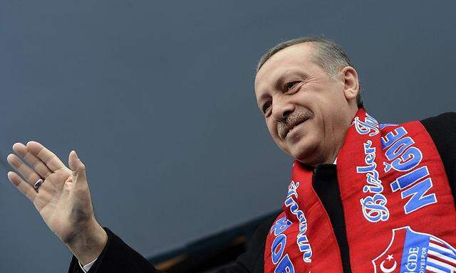 Turkey's Prime Minister Erdogan greets his supporters during an election rally of his ruling AK Party