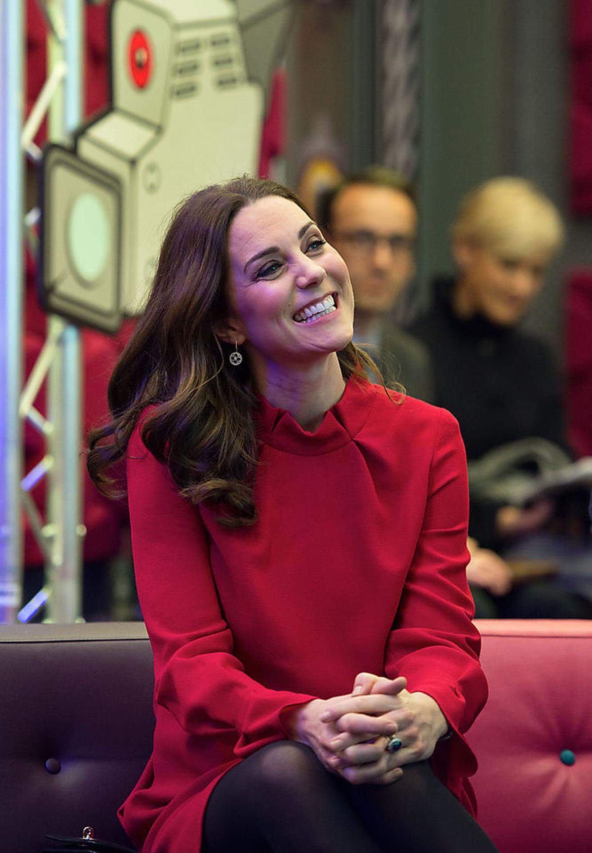 Unter dem Mantel versteckte die Herzogin auch ein festlich-rotes Kleid von Goat - einer britischen Marke, die sie während ihren Schwangerschaften präferiert - mit coolem Kragen. Nicely played. Ja, Kate. Wir freuen uns auch.