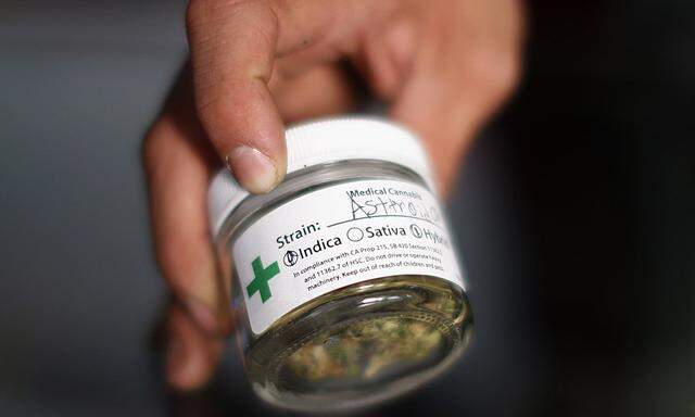 A volunteer displays cannabis buds at the La Brea Collective medical marijuana dispensary in Los Angeles