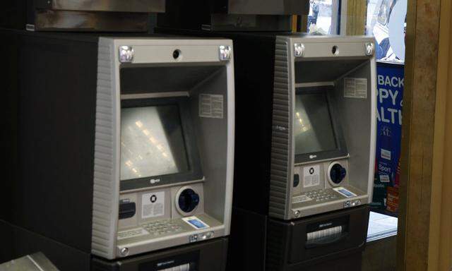 JPMorgan Chase ATMs stand near a door as customers walk past a Duane Reade store in New York