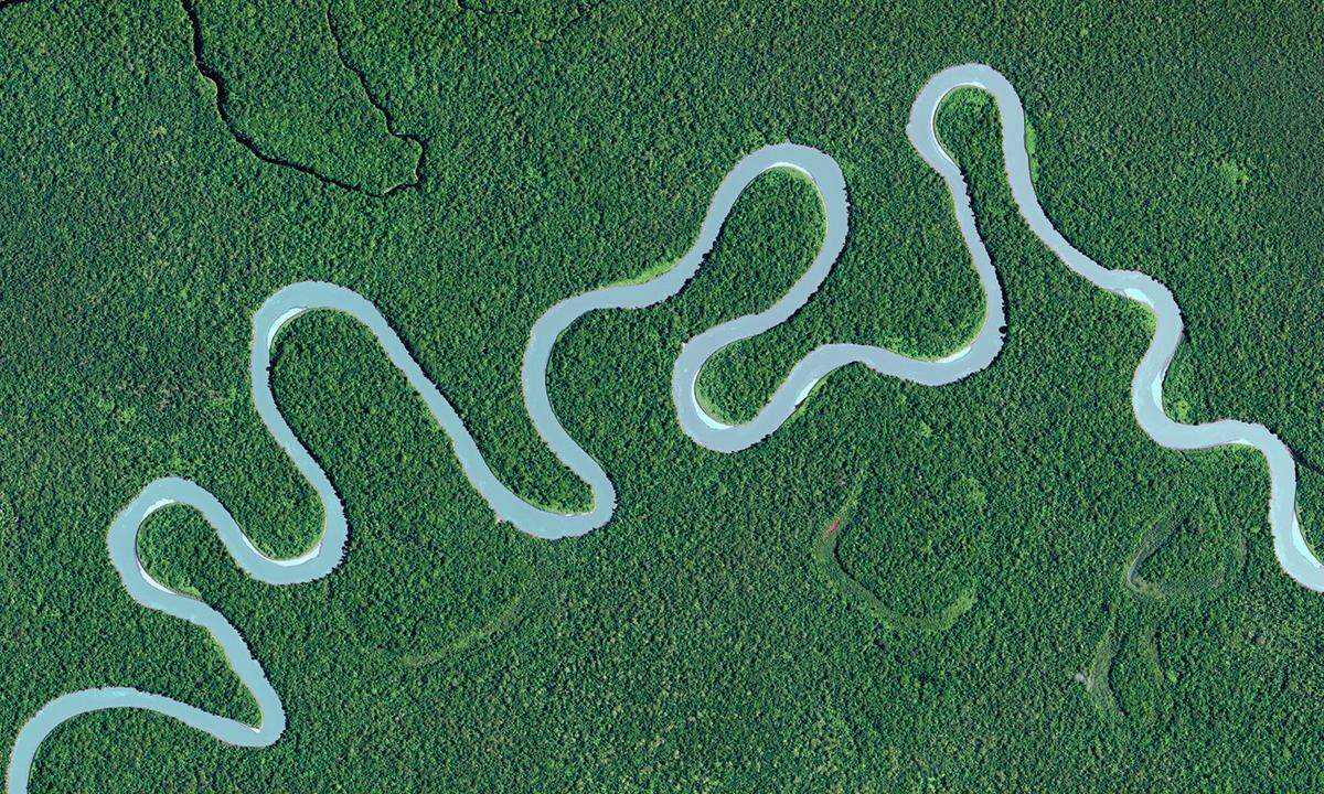 Des Fluss Akimeugah mäandert durch die flache Landschaft des Lorentz-Nationalparks im Westen von Papua-Neuguinea. Die dichten Wälder der Tropen sind mit der wichtigste Bestandteil des Klimasystems der Erde.