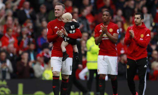 Manchester United´s Wayne Rooney with his son Kit after the match