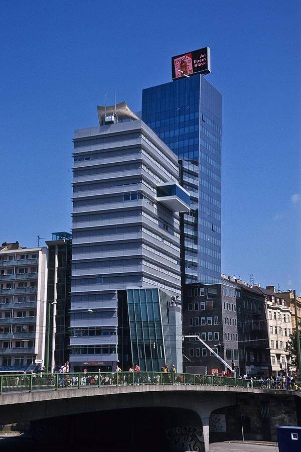 Den Media-Tower, Sitz der Verlagsgruppe News, am Wiener Schwedenplatz von 2001 krönt eines der für Hollein charakteristischen Flugdächer.