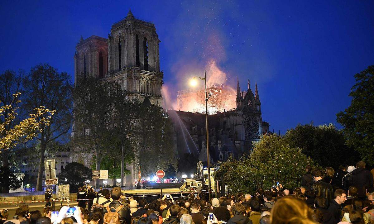 Binnen kürzester Zeit versammelten sich Hunderte Menschen am Seine-Ufer und beobachteten, wie das Pariser Wahrzeichen in Flammen steht. Viele begannen zu beten. Mancherorts wurde auch "Ave Maria" angestimmt.