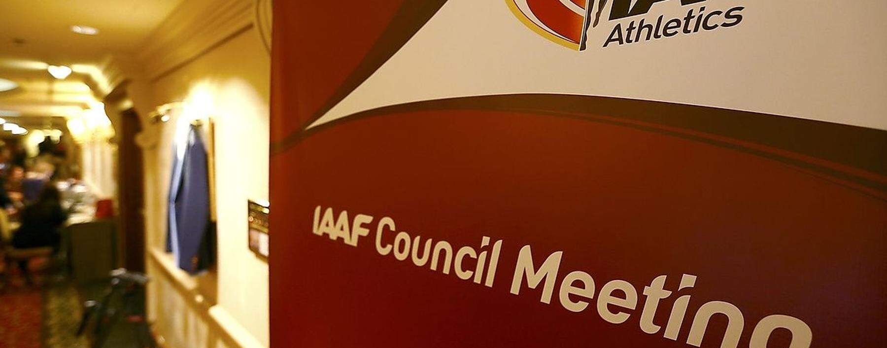 Journalists are seen near a logo of the IAAF at a hotel where the IAAF council holds a meeting in Vienna