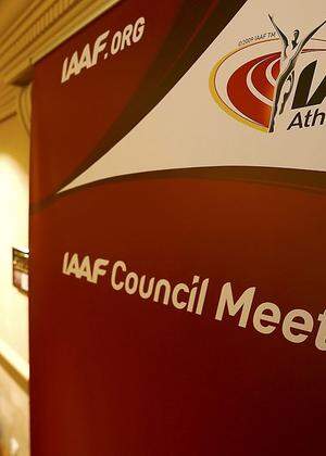 Journalists are seen near a logo of the IAAF at a hotel where the IAAF council holds a meeting in Vienna