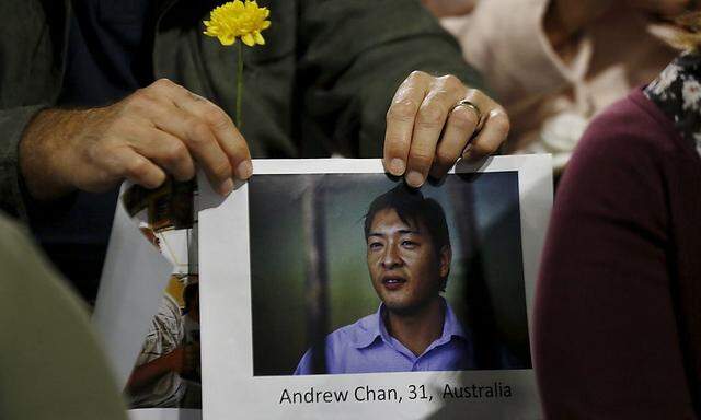 A supporter of Australian convicted drug trafficker Andrew Chan holds a picture of him at a vigil in Sydney