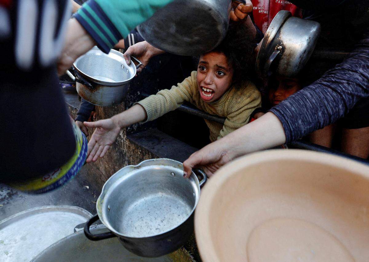 14. März. In Rafah im südlichen Gazastreifen warten Menschen auf Nahrungsmittel-Spenden. Auch im Fastenmonat Ramadan muss die Bevölkerung unfreiwillig hungern.    