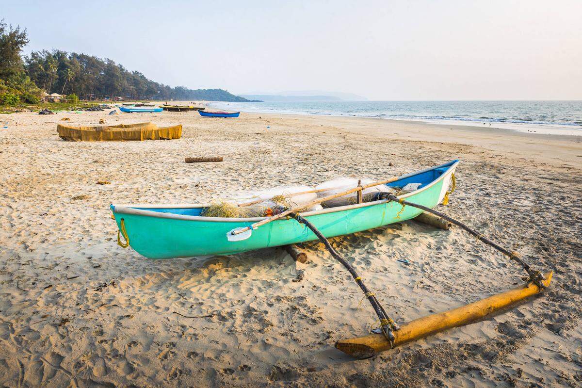 Das einsame Fischerboot an einem Strand im indischen Goa. Ein Hauch Einfachheit und Freiheit liegt in der Luft.