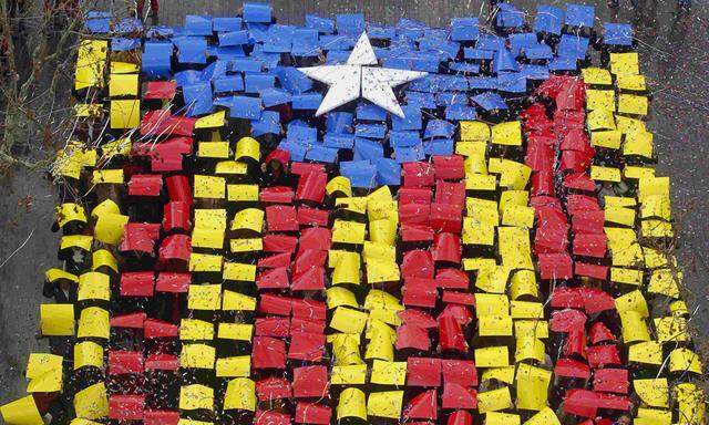 People hold placards to form a giant ´Estelada´ flag in front of Sant Feliu townhall, near Barcelona