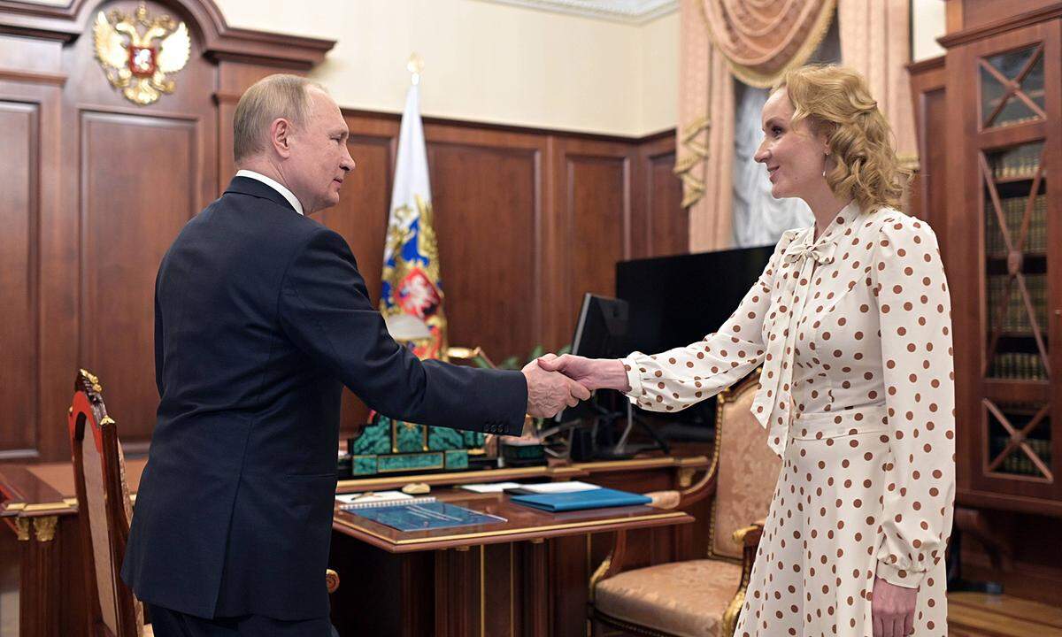 Russia Putin 8136489 09.03.2022 Russian President Vladimir Putin shakes hands with Presidential Commissioner for Childr