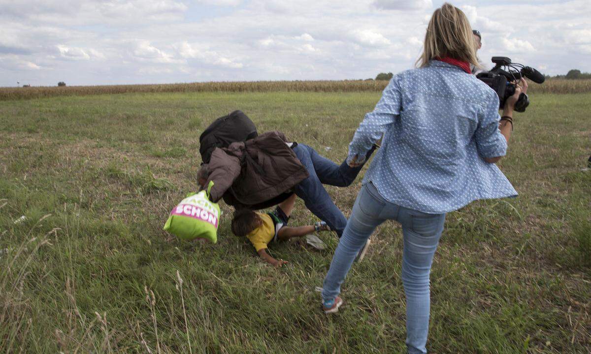 8. September 2015. Ein Bild einer Szene, die ein gerichtliches Nachspiel hatte: Eine Kamerafrau stellt einem Flüchtling mit Kind auf dem Arm ein Bein, als diese von einem Sammelpunkt in Röszke wegrennen. Der Oberste Gerichtshof Ungarns urteilte 2018, das Verhalten der Journalistin sei zwar "moralisch falsch und illegal" gewesen. Es habe sich aber nicht um Vandalismus gehandelt, wie es die vorherigen Instanzen gesehen hatten. 