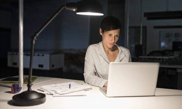 Businesswoman in office using laptop in the dark model released Symbolfoto property released PUBLICA