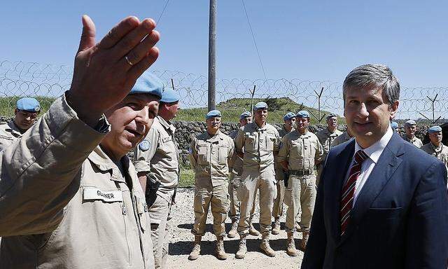 Austrian Foreign Minister Spindelegger listens to Lieutenant-Colonel Glanner during his visit of the Austrian U.N. peacekeepers on the Israeli occupied Golan Heights