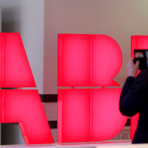 FILE PHOTO: Man takes pictures of logo of Swiss power technology and automation group ABB ahead of a news conference to present full year results in Zurich