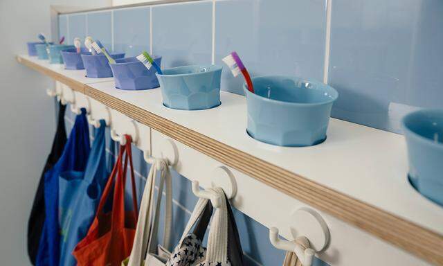 Line up of of toothbrushes and bags on hooks in kindergarten property released PUBLICATIONxINxGERxS