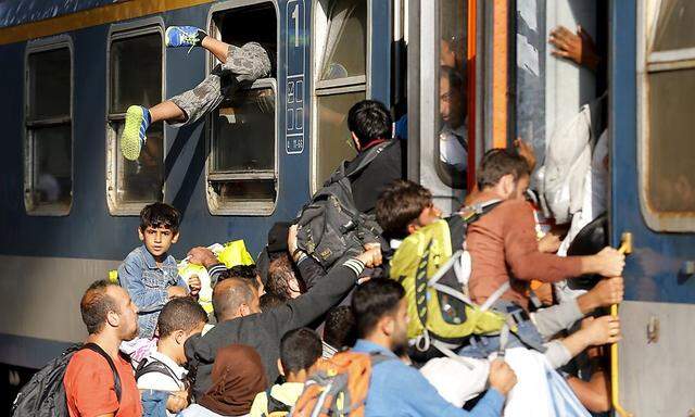 Migrants storm into a train at the Keleti train station in Budapest, Hungary