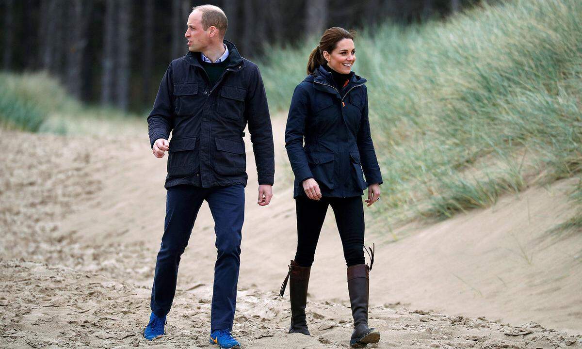 Später stapfen die Cambridges über walisische Strände. Ein Plausch mit Pfadfindern und Strandreinigung stand auf der royalen To-Do-Liste. Für den Außeneinsatz schlüpft Kate in den Wax Parka von Troy London und – sicher ist sicher – in ihre Steppjacke von Barbour, die sie darunter versteckt. Überhaupt scheint die Herzogin zu wissen, wie man sich für die ungemütliche Kombination aus nasskaltem Wetter, Wind und Sand rüstet. In ihren Lieblingsstiefeln von Penelope Chilvers hat Kate (im Gegensatz zu Ehemann Prinz William in Turnschuhen) garantiert trockene Füße.