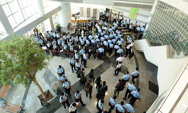 Police officers gather at the headquarters of Apple Daily in Hong Kong