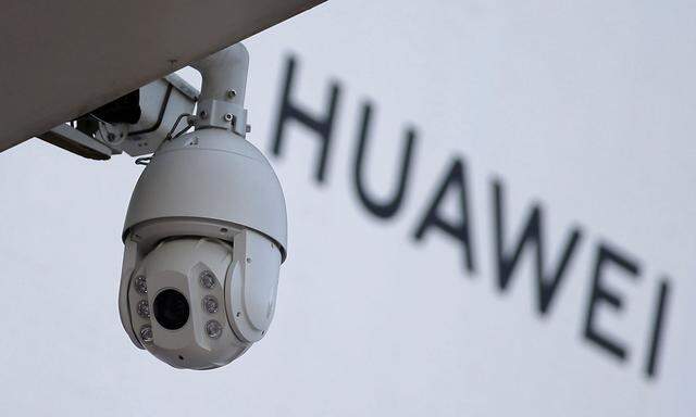 FILE PHOTO: A surveillance camera is seen next to a sign of Huawei in Beijing
