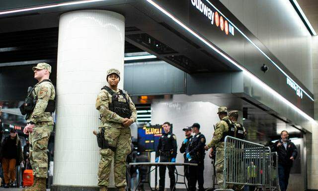Soldaten der New Yorker Nationalgarde und städtische Polizisten postieren sich am Eingang einer U-Bahn-Station. Ihre Präsenz ändert wenig an Vorfällen im Öffi-System.