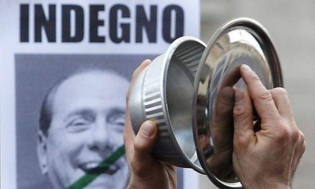 A protestor bangs pots and pans as he takes part in a demonstration calling for the resignation of It