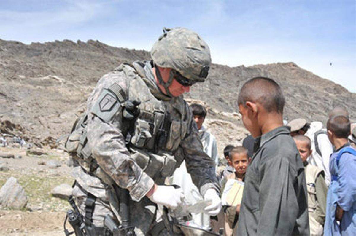 Technical SGT (Sani) Mathew Wiese; Illinois, stationiert in Missisippi verarztet in Sultankhel (Provinz Kapisa) einen afghanischen Jungen mit einer Kopfverletzung.