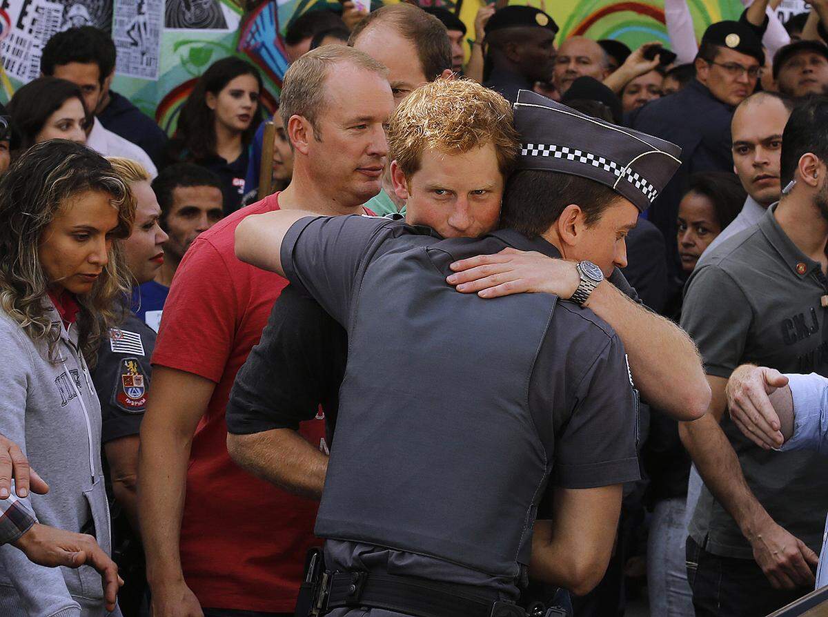 Herzlicher Abschied. Der britische Prinz Harry umarmte einen Polizisten, nachdem er ihn durch Sao Paulo gefuhrt hatte.  26. Juni 2014