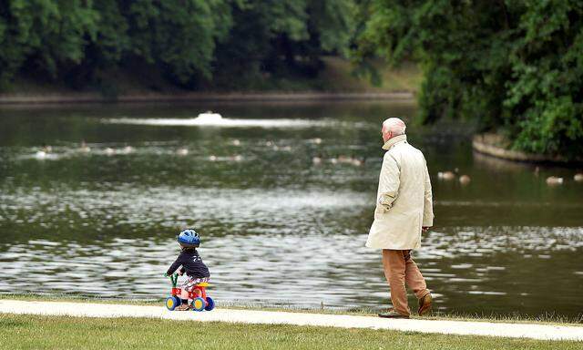 A man walks behind a boy in a park in Brussels