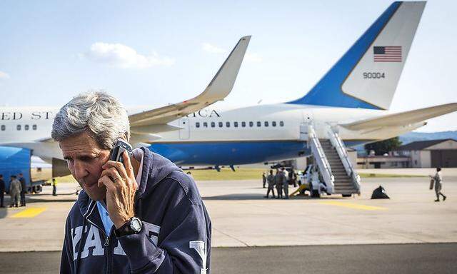 U.S. Secretary of State John Kerry speaks on his phone while his plane refuels at Ramstein Air Base in Ramstein-Miesenbach