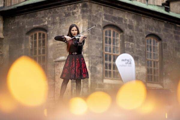 Violinist Mia Nova plays by the sea of ​​lights,