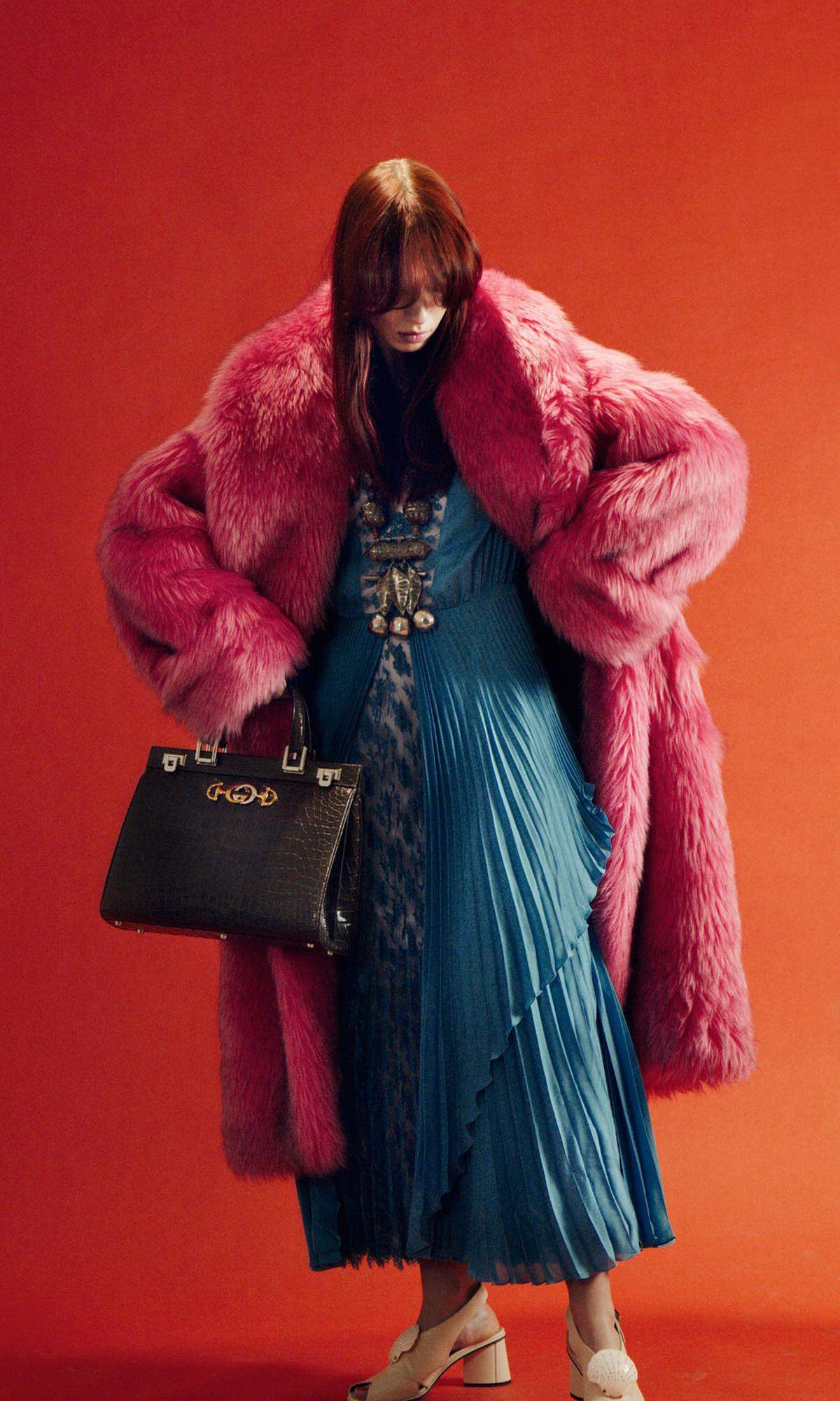 Gucci. Marei trägt ein Plisseekleid in Blau, einen Mantel in Kunstpelz, Pumps und die Tasche „Zumi" in Krokodilleder.