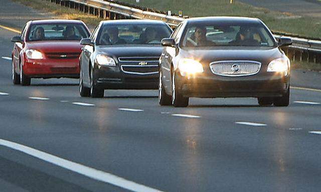 General Motors CEO Richard Wagoner, second vehicle passenger seat, travels in a three-car convoy with