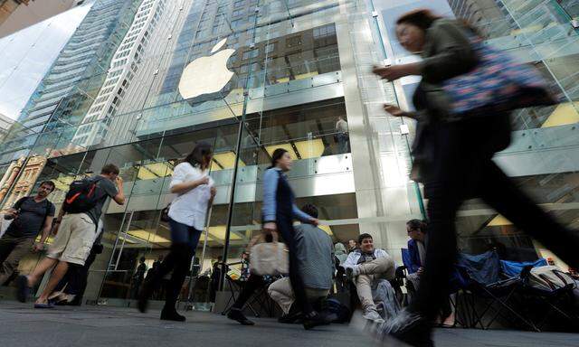 Pedestrians walk past buyers of new Apple products who have begun to camp outside the company´s flagship Australian store in Sydney