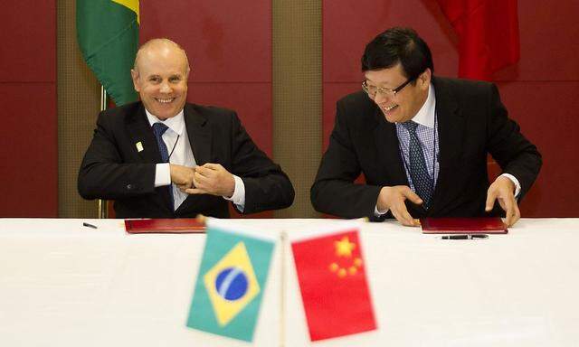 Brazilian Minister of Finance Mantega and Chinese Minister of Finance Lou smile after signing a memorandum at the 5th BRICS Summit in Durban