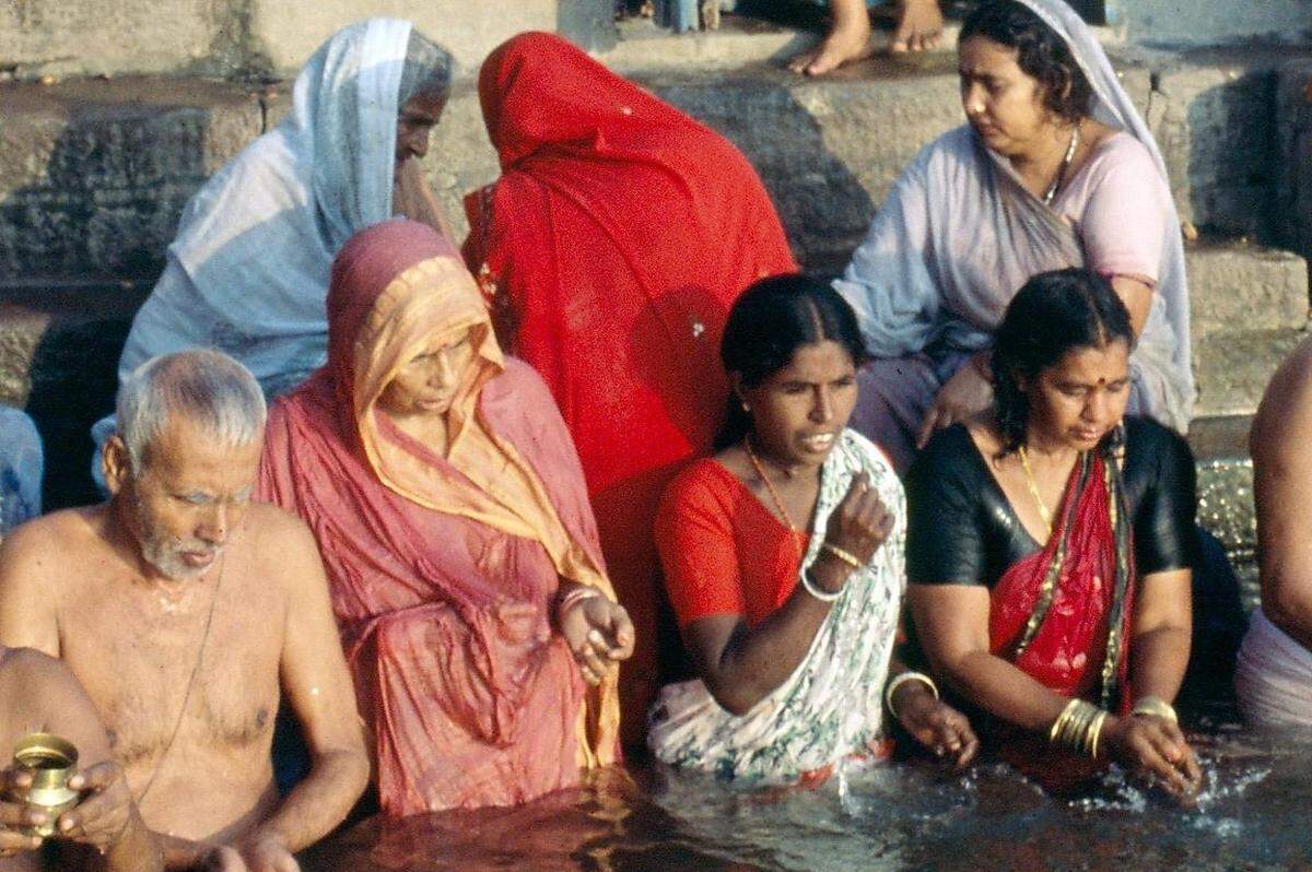 Außerhalb von Europa ist FKK- Baden sehr verpönt. In muslimischen Ländern gehen Frauen mit ihrer ganzen Kleidung ins Wasser.  Im Bild: Varanasi (IND)- Frauen baden mit ihren Saris während die Männer sich bis auf die Unterwäsche entkleiden. 