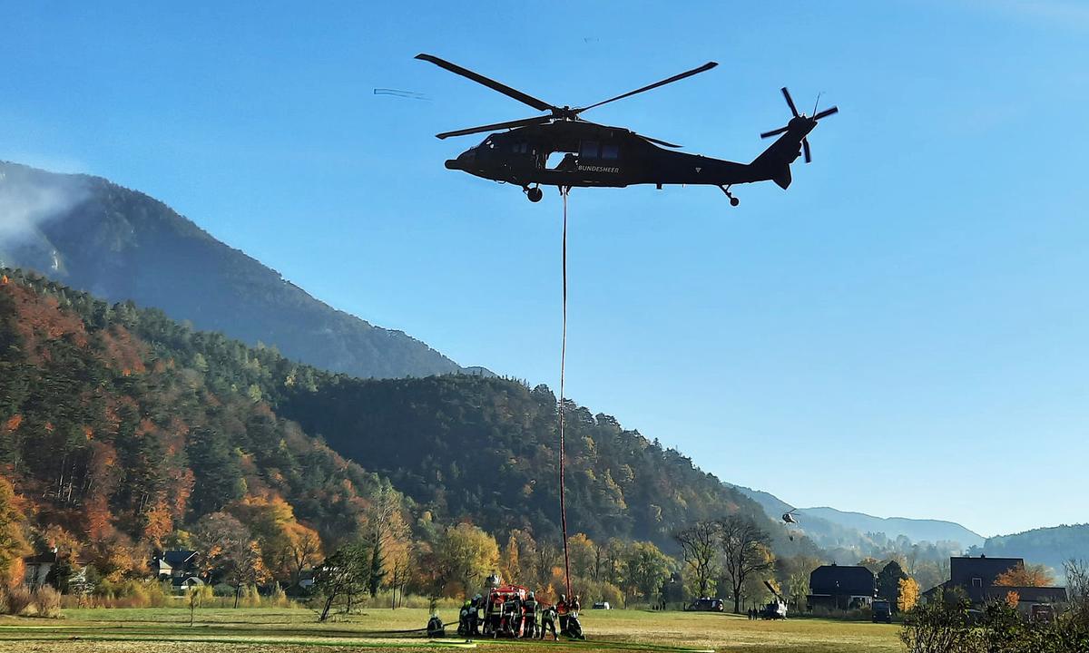 Ein Bundesheer-Hubschrauber beim abheben mit Löschwasser