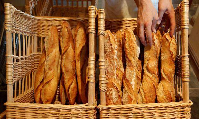 FILE PHOTO: A French baker places freshly-baked baguettes in wicker baskets in his shop in Strasbourg