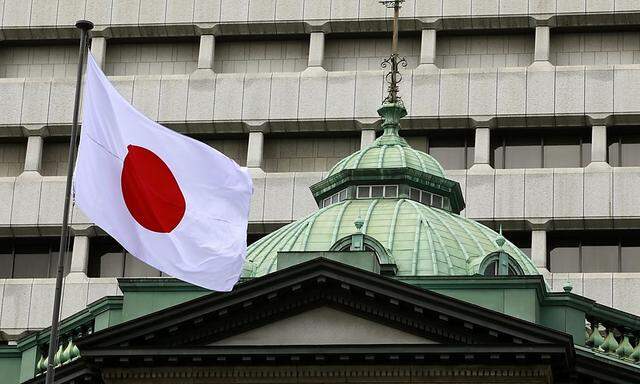 A Japanese flag flies atop the Bank of Japan building in Tokyo