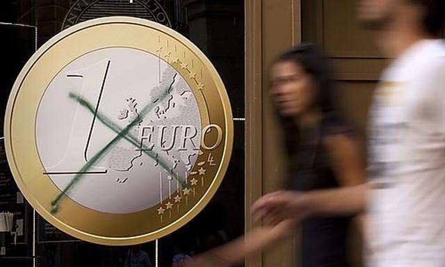 People walk past a pizza shop with a euro sign which was crossed out in central Madrid